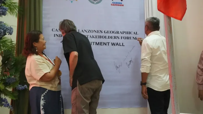 Stakeholders, led by Mambajao Sangguniang Bayan member Zita Abellare, REDD lead consultant Peter Damary, and local leaders, sign a commitment wall during the Camiguin Lanzones Geographical Indication Stakeholders Forum at the New Provincial Capitol in Mambajao.
