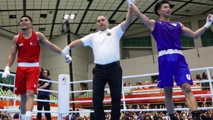Uzbek referee Maruf Urdushev raising the hand of Japanese boxer Rui Yamaguchi inside the ring following his split-decision victory over Filipino Olympic silver medalist Carlo Paalam in the men's 55kg boxing final at the 2026 Asian Games.