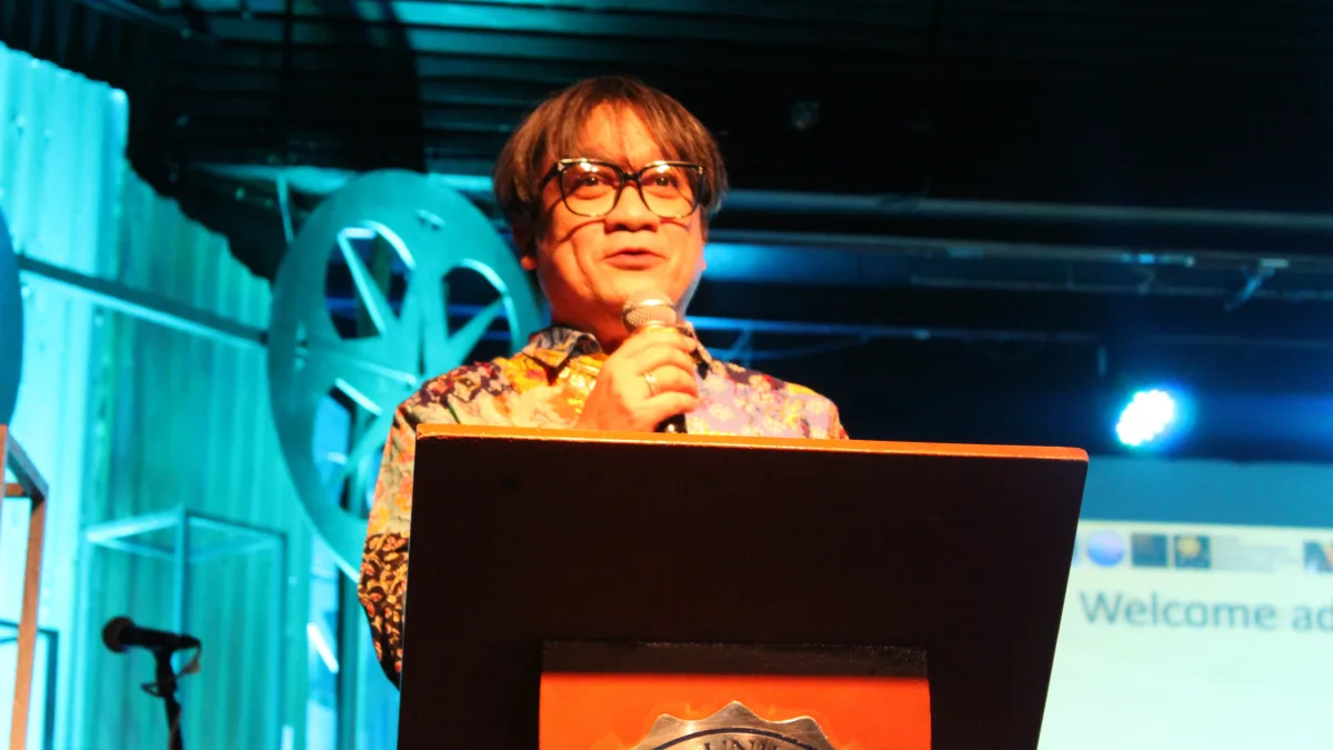 Cinemagis 16 Festival Director Dr. Hobart P. Savior addresses the audience at a podium inside the Xavier University Little Theater in Cagayan de Oro City during the opening of the 16th Northern Mindanao Film Festival.