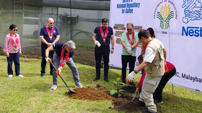Department of Agriculture and Nestlé Philippines officials lead a ceremonial tree-planting ceremony for the DA-RFO X National Repository for Coffee during International Coffee Month celebrations in Malaybalay City, Bukidnon.
