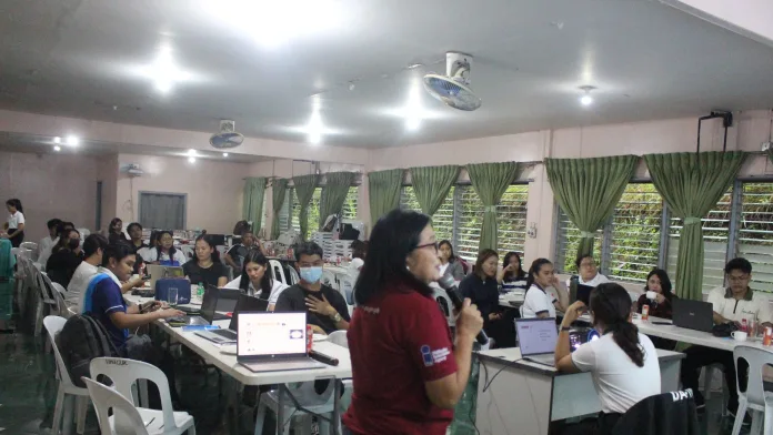 PIA-10 resource speaker Ruby Leonora Balistoy speaks into a microphone before information officers and media partners during a mobile journalism training workshop held at the Northern Mindanao Agricultural Crops and Livestock Research Complex in Malaybalay City, Bukidnon.