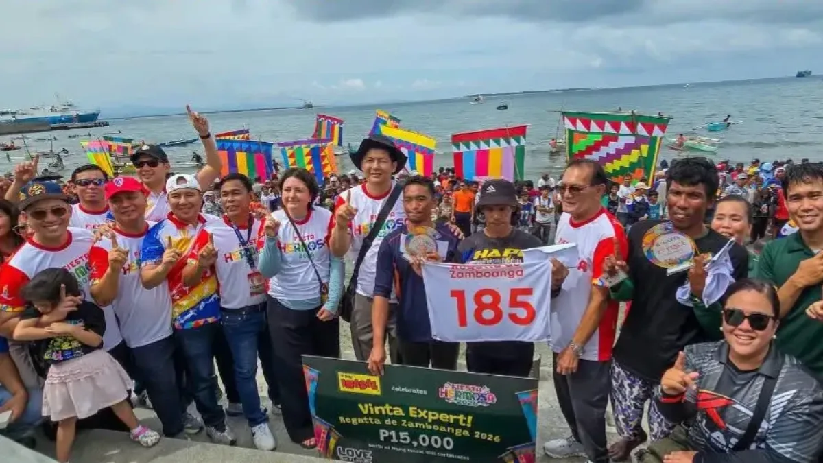 Champion paddlers Danny Ladja and Hajad Hamid of Vinta No. 185 pose with Zamboanga City officials, family members, and the ₱50,000 top prize banner along the Zamboanga City coastline during the Regatta de Zamboanga.