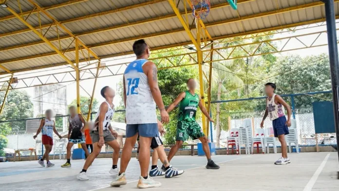 Persons Deprived of Liberty (PDLs) participate in a basketball tournament on a covered court at the Davao Oriental Provincial Rehabilitation and Reformatory Center.