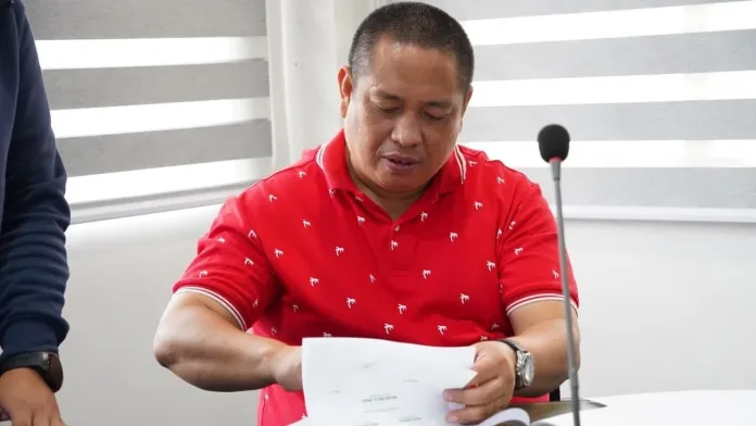 City Councilor Dr. Jerome Magan, chairperson of the Sangguniang Panlungsod Committee on Health in Gingoog City, reviewing official public health documents during a council session.