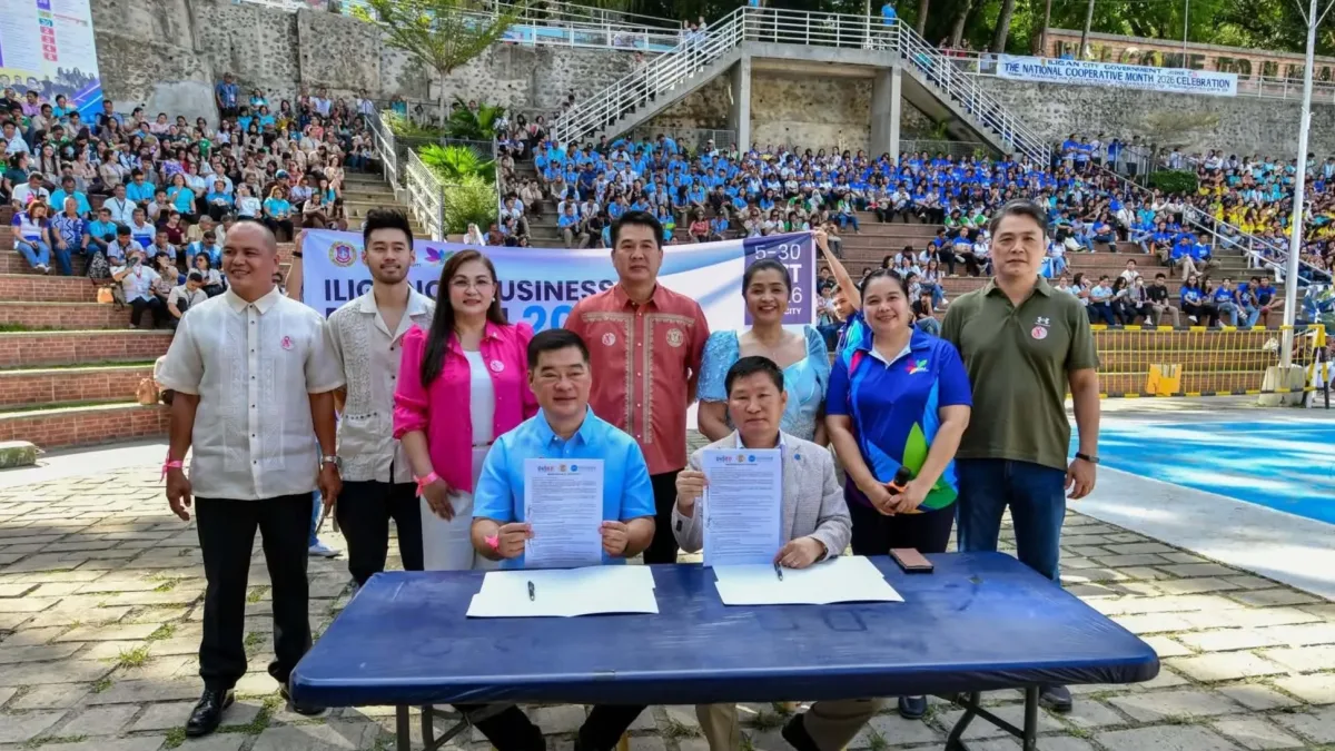 Iligan City Mayor Frederick W. Siao and Korean Freedom Federation President Capt. Yunkwon Ko hold signed memorandum of understanding documents at a blue table in front of city officials and event attendees at Iligan City Hall.