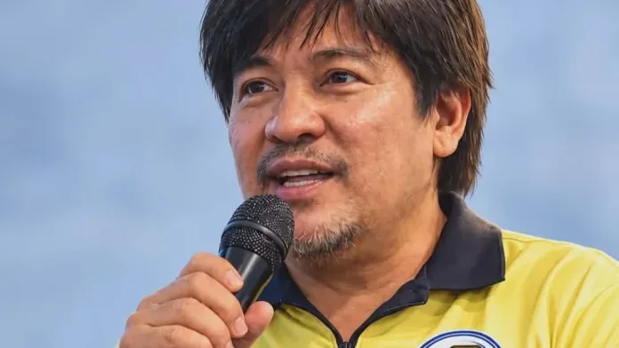 Joel Tongco, Federation of Free Workers (FFW) deputy vice president for Mindanao and Macajalar Employees Union–FFW president, holds a microphone while speaking at a forum.