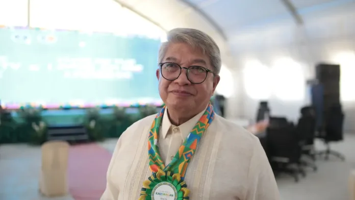 Kauswagan Vice Mayor Rommel C. Arnado, wearing a Barong Tagalog and ceremonial floral lei, stands inside the Kauswagan International Organic Convention Center during an interview on municipal water source development.
