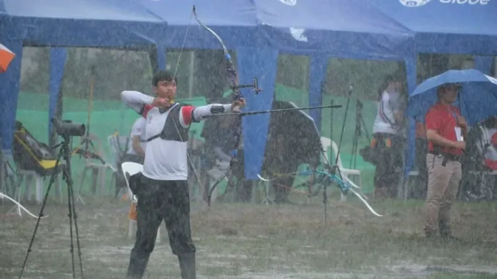 Young archer Lester Ian Datiles of the Cagayan de Oro-Misamis Oriental Archery Club poses with his recurve bow equipment on a target field.
