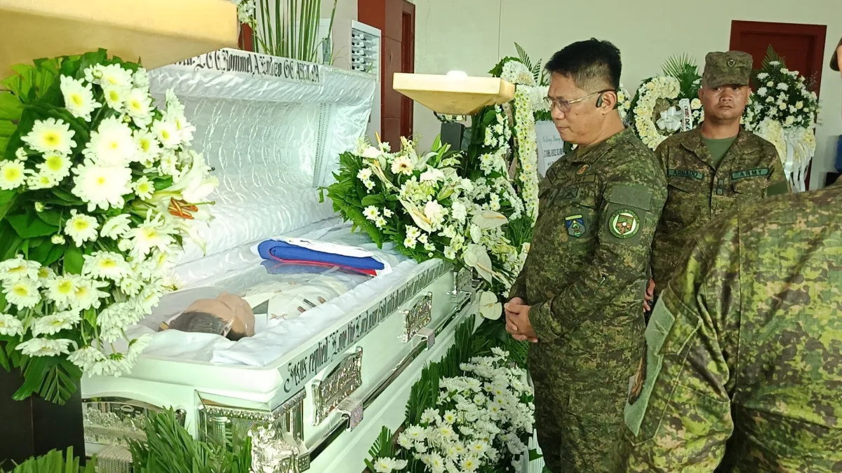 Brig. Gen. Bernardo A. Taqueban stands in silent reflection beside the white casket of Lt. Col. Rommel A. Endozo during a military wake in Iligan City.