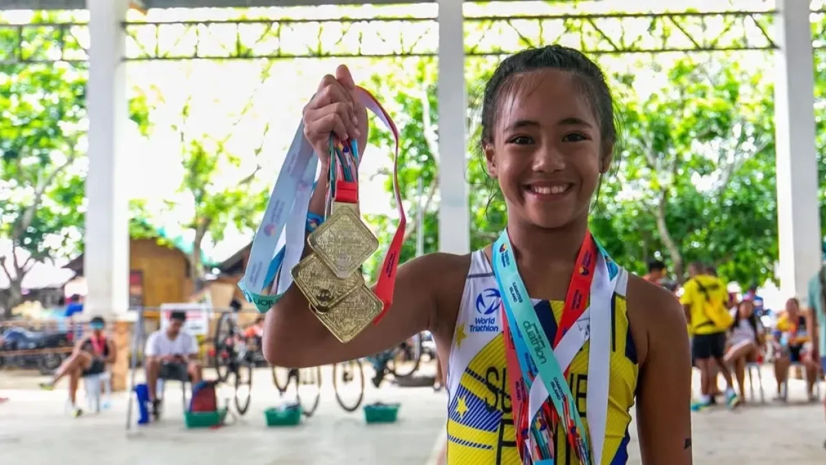 Nine-year-old triathlete Ma. Georjina Concepcion Pacquing Sumaje of Zamboanga City proudly holds up three gold medals after sweeping her events at the 2026 National Age Group Triathlon Camotes Island Series in Cebu.