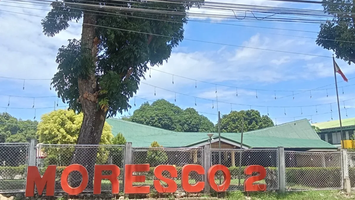 The red "MORESCO 2" sign stands along a wire fence in front of the Misamis Oriental II Rural Electric Service Cooperative office building in Medina, Misamis Oriental.