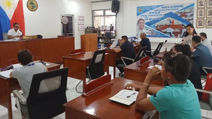 Members of the Medina Sangguniang Bayan Committee on Transportation and Public Safety convene in the session hall during a meeting chaired by Councilor Esmael Naguib Jr. to discuss driver regulations, passenger complaints, and municipal traffic signage.