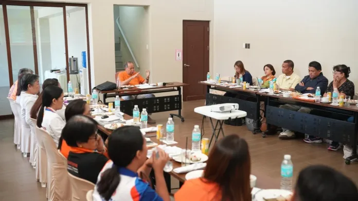 Misamis Occidental Governor Henry S. Oaminal gestures while presiding over an executive meeting with provincial department heads around a U-shaped table setup.