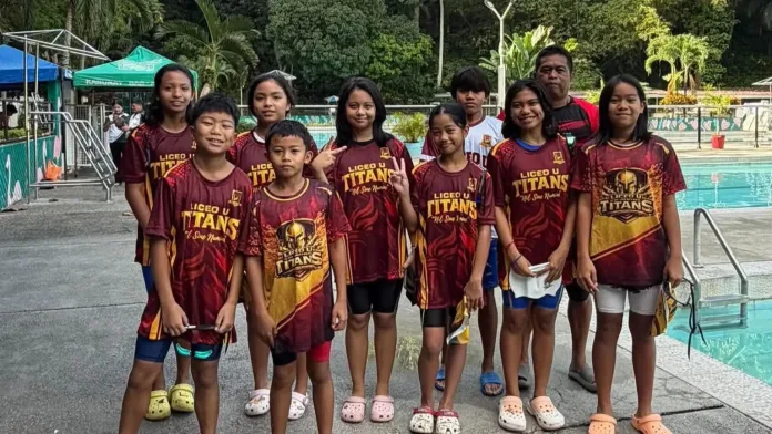 Young student-athletes of the Liceo Titans swimming squad and head coach Arvin Parajes pose poolside in maroon and gold Liceo U Titans jerseys at the Kagay-an Lawndale Spring Resort.