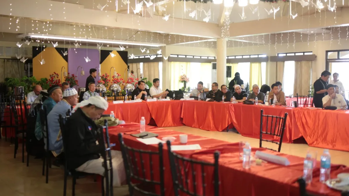 Officials of the National Commission on Muslim Filipinos, accredited sheiks, and partner agency representatives sit around a U-shaped conference table decorated with red tablecloths during the Hajj 2027 Stakeholders Conference.