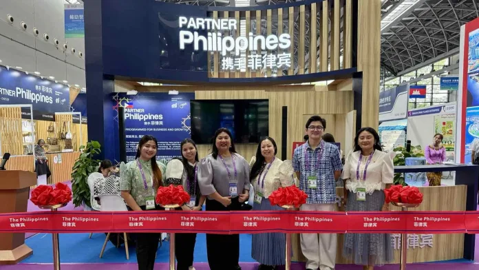 Exhibitors and trade representatives pose behind a ribbon-cutting line at the Philippine Pavilion during the 23rd China-ASEAN Expo in Nanning, Guangxi, China.