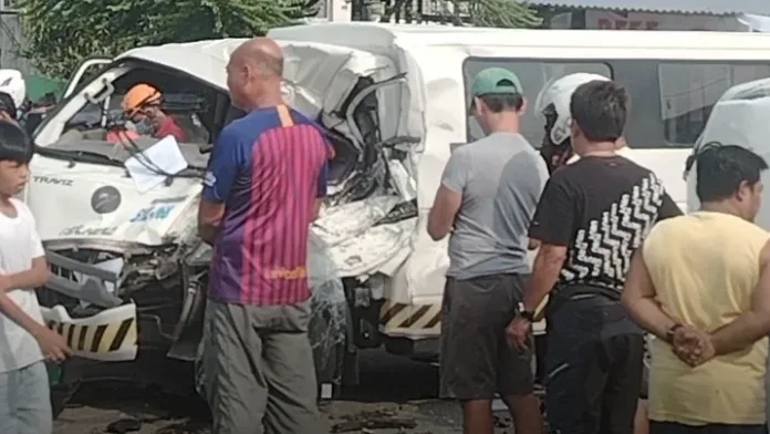 Rescuers and onlookers gather around the heavily damaged front cabin of a white utility van involved in a three-vehicle collision along the national highway in Barangay Luyong Bonbon, Opol, Misamis Oriental.