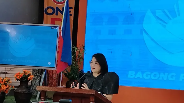 Palace Press Officer Undersecretary Atty. Claire Castro speaks at a wooden podium next to the Philippine flag during a press briefing in Cagayan de Oro City.