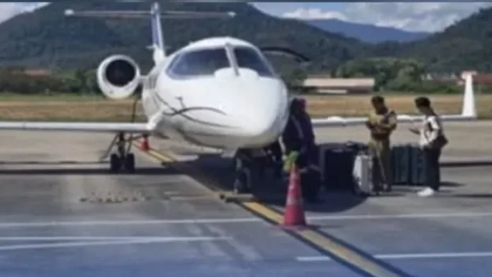 A white Learjet 55B private plane sits parked on the tarmac at Luang Prabang International Airport in Laos as ground personnel stand nearby next to luggage following the interception of 521 kilograms of shabu.