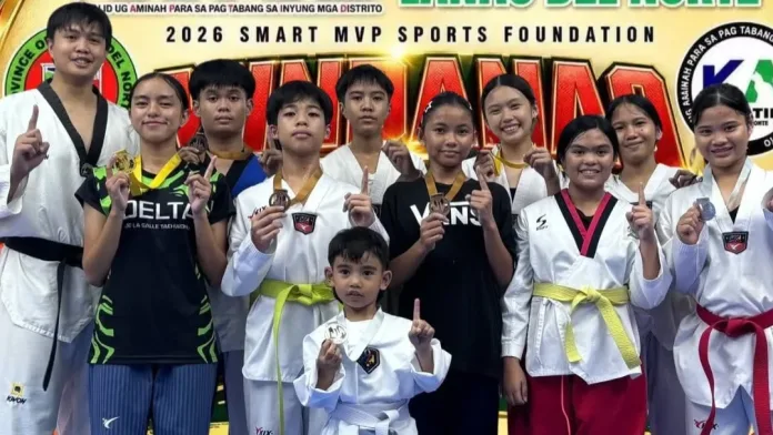 Young student-athletes from Pinecrest Taekwondo Center of Manolo Fortich, Bukidnon, wearing uniform doboks and medals, pose with head coach Miguel Lim during the 2026 Mindanao Best of the Best Taekwondo Championships.