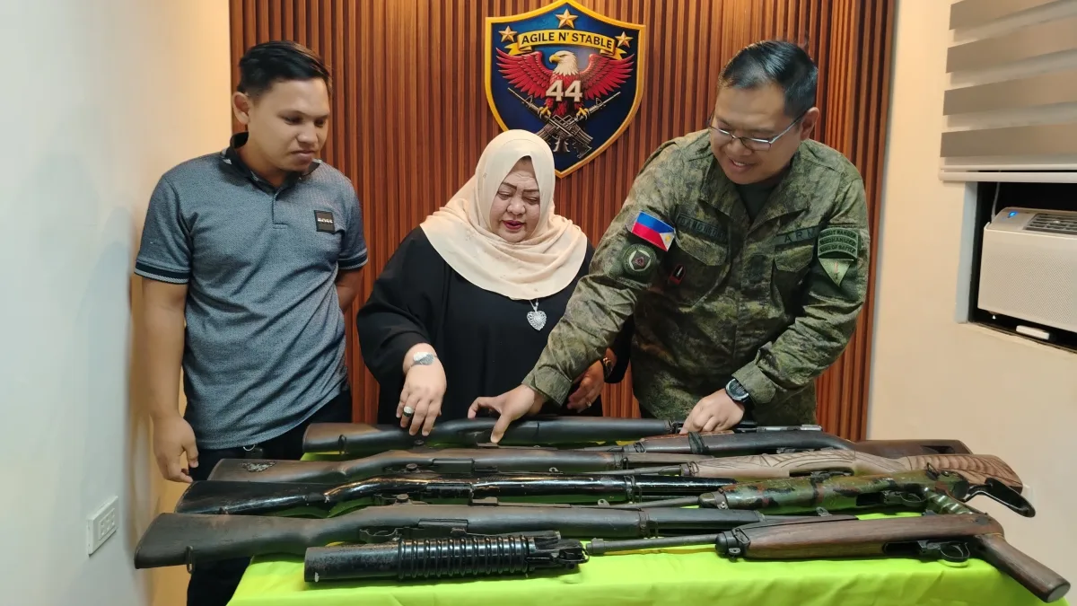 Poona-Piagapo Mayor Ashley “Kaulit” Rakiin and 44th Infantry Battalion Commander Lt. Col. Jeremy Damonsong inspect nine surrendered loose firearms displayed on a table at the 44IB headquarters in Balo-i, Lanao del Norte.