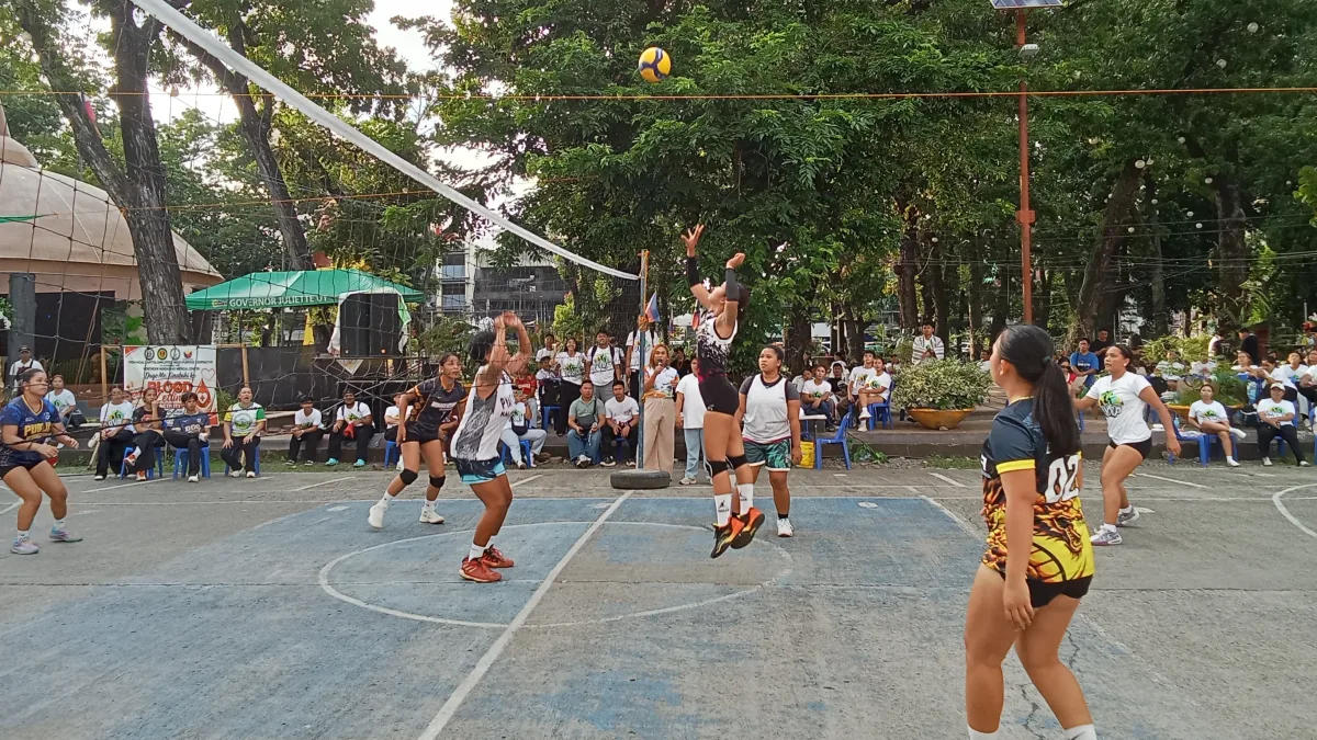 A volleyball player jumps at the net to set the ball during the Pag-asa Youth Association of the Philippines women's championship game at the Misamis Oriental Provincial Capitol Grounds.