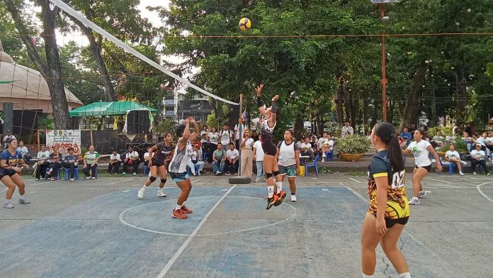 A volleyball player jumps at the net to set the ball during the Pag-asa Youth Association of the Philippines women's championship game at the Misamis Oriental Provincial Capitol Grounds.