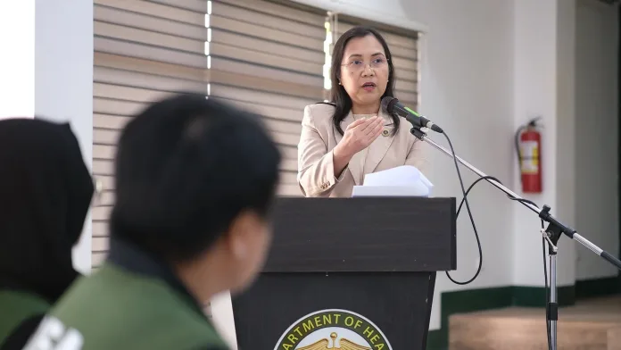 Regional Prosecutor Merlynn Barola-Uy speaks into a microphone at a podium during the Regional Inter-Agency Committee on Anti-Illegal Drugs Coordinating Group 10 meeting in Cagayan de Oro City.