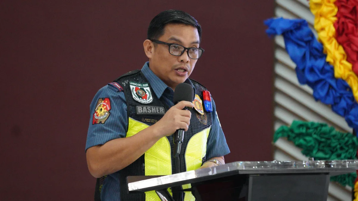 Police Lt. Col. Salahuddin Basher, chief of the Lanao del Sur Police Provincial Community Affairs and Development Unit, speaking into a microphone at a podium during a security council meeting.