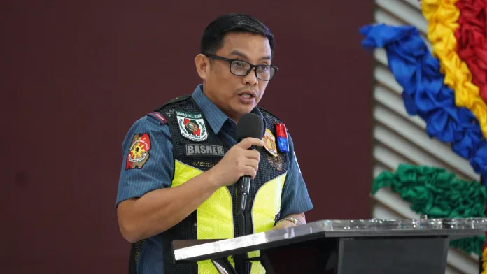 Police Lt. Col. Salahuddin Basher, chief of the Lanao del Sur Police Provincial Community Affairs and Development Unit, speaking into a microphone at a podium during a security council meeting.