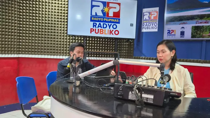 SEC-Cagayan de Oro communication officer Neil Maynard Conde speaks into a broadcast microphone alongside a PIA-10 anchor inside the DXIM Radyo Pilipinas Cagayan de Oro radio studio.