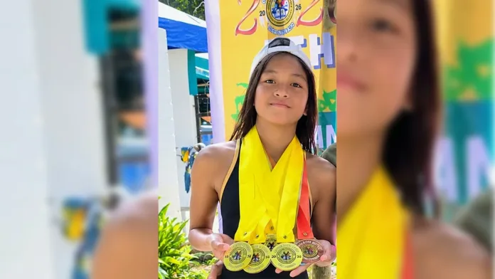 St. Mary’s School student-athlete Alexa Ann T. Epan holds up multiple gold, silver, and bronze swimming medals around her neck in Cagayan de Oro City.