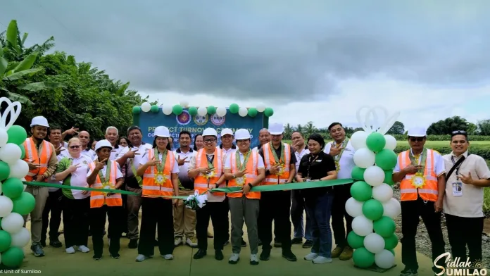 Sumilao Mayor Venice Marie P. Villo leads municipal officials and engineers in cutting a green ceremonial ribbon during the turnover of ₱25 million worth of farm-to-market roads in Sumilao, Bukidnon.