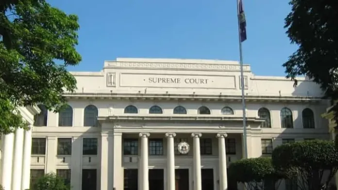 The facade of the Supreme Court of the Philippines building in Manila, featuring classical white columns and the judicial seal on its entrance portico.