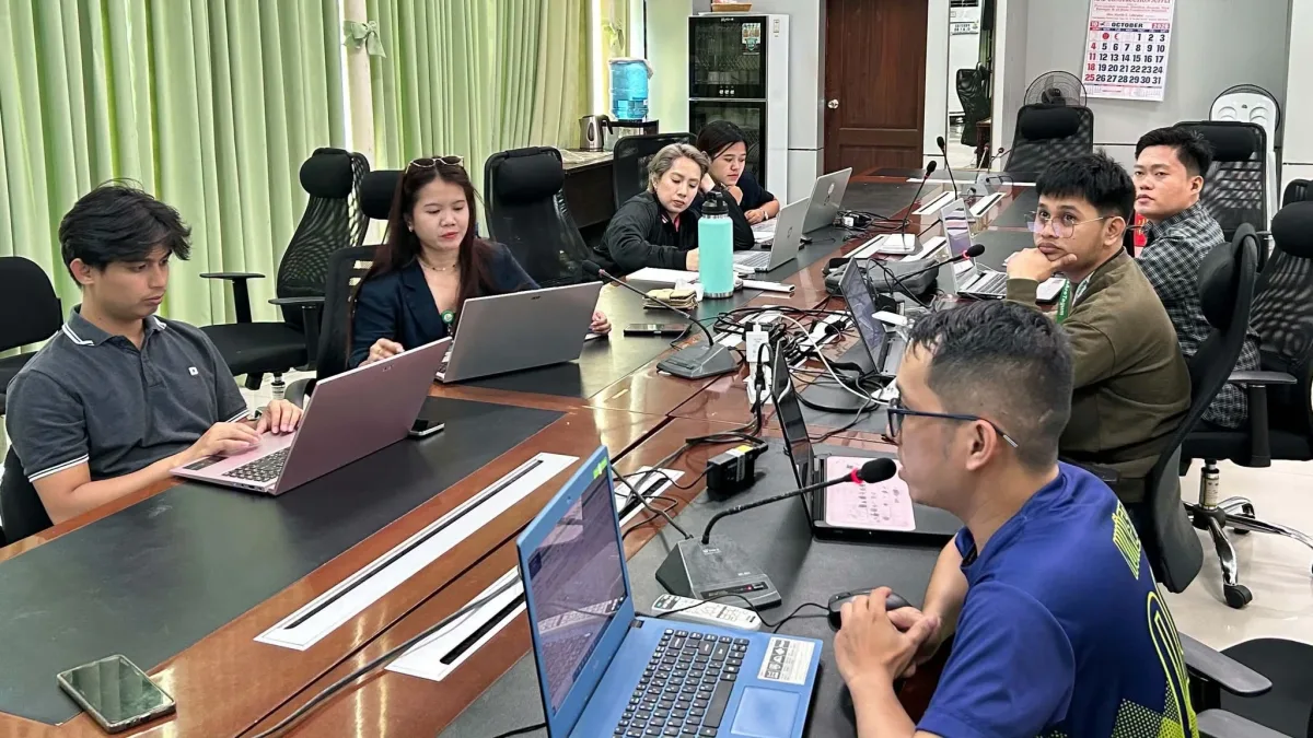 Tagum City Youth and Sports Development Office personnel working on laptops around a conference table during a financial and procurement training session in Tagum City.