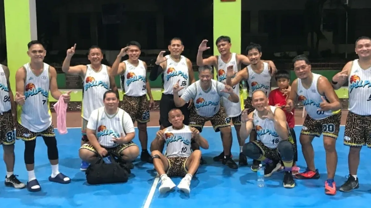 Members of Team Escobido in white and patterned Ballpals basketball jerseys smile, pose, and celebrate on the court at Misamis Oriental General Comprehensive High School after winning the 2026 President’s Cup championship.